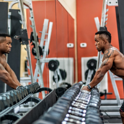 Man looking at himself in the mirror at a gym